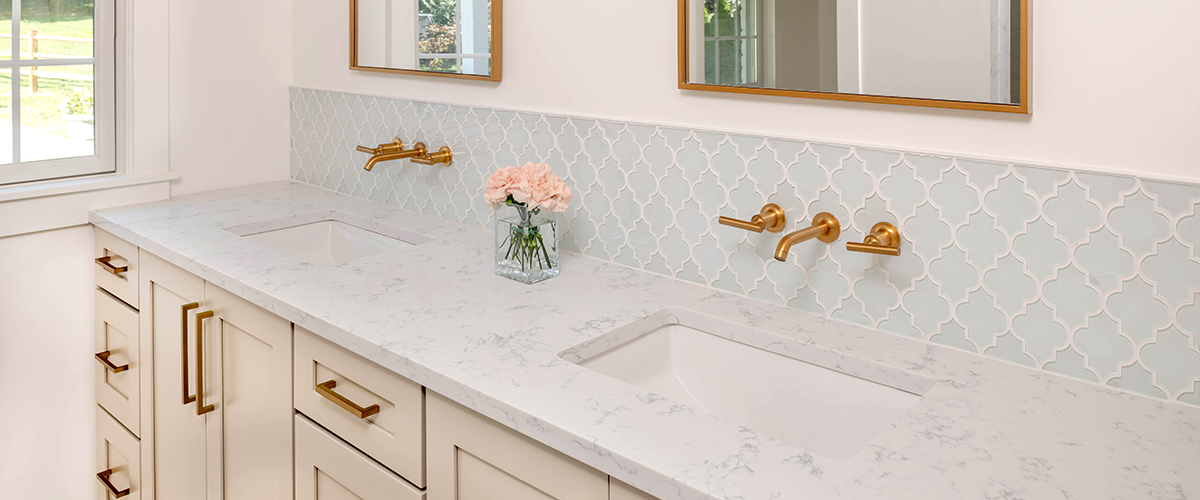 White marble top and light blue backsplash of double vanity bathroom by Hazley Builders