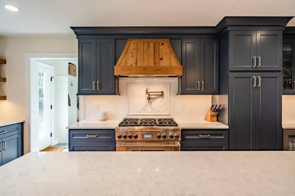 Kitchen with blue cabinets and wood range hood