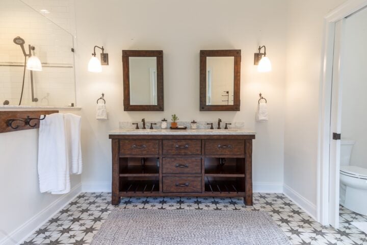 Double sink vanity in dark wood with bold patterned floor tile