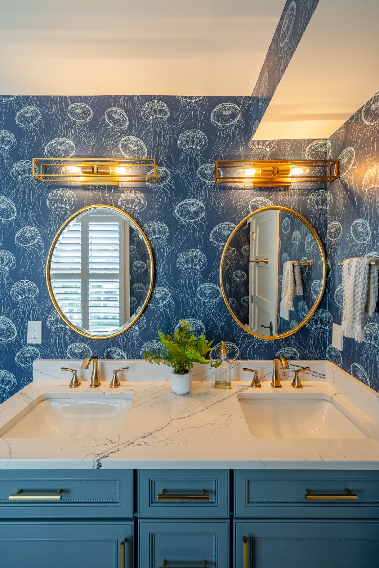 Double sink vanity against a blue wall wrapper and round mirrors