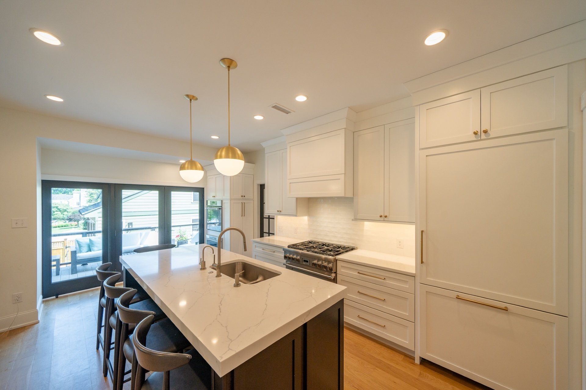 Classic custom white kitchen with brass globe pendants over island