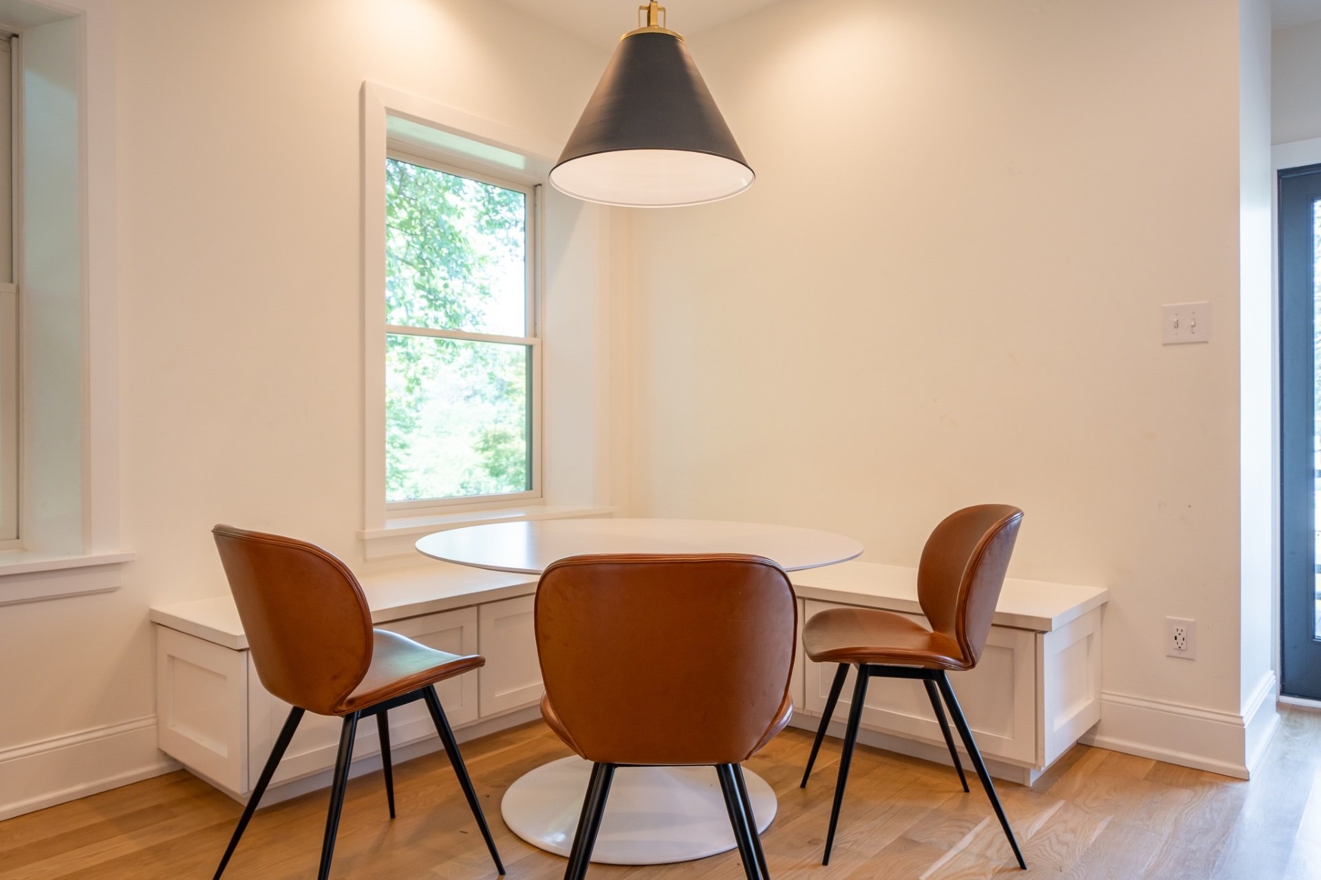 Small dining area with modern black conical pendant lamp