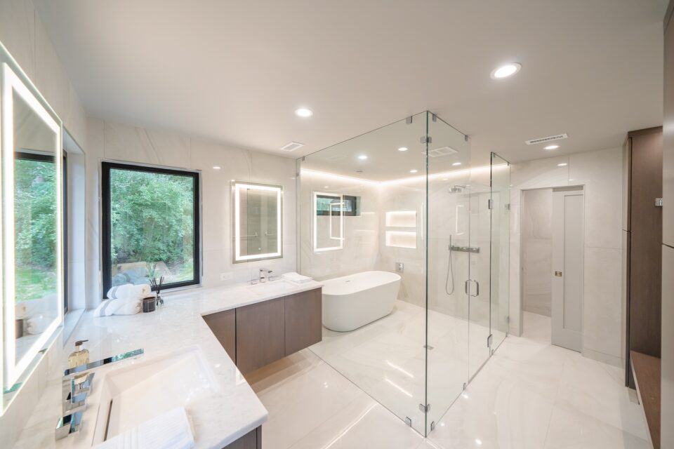 Bright luxury bathroom with full glass shower and tub enclosure