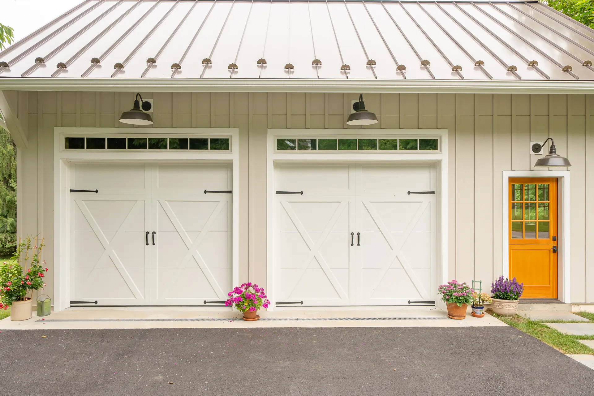Potting shed mudroom with wood paneling, a wreath, and the orange Dutch door open to the driveway