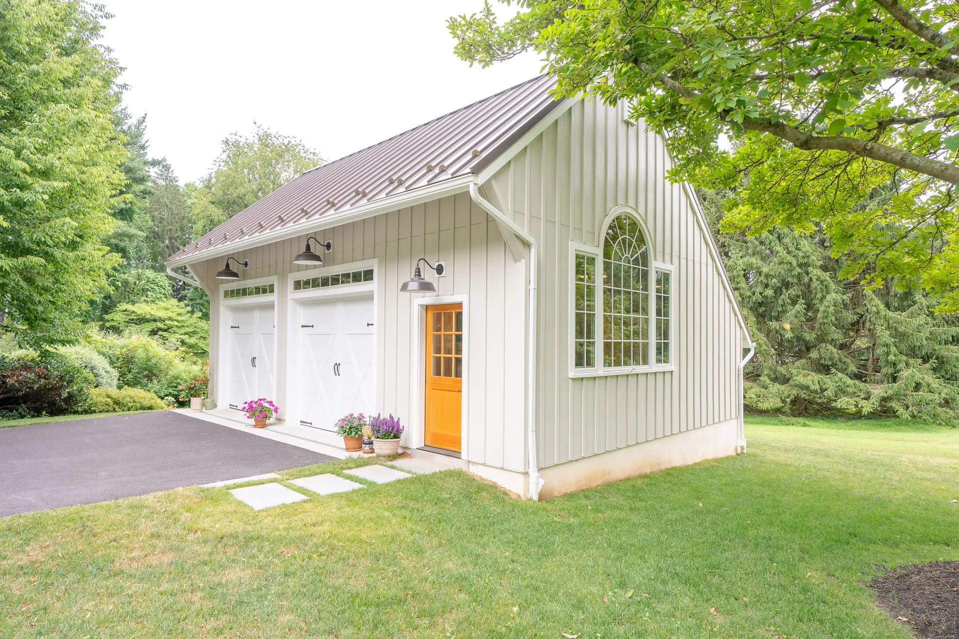 French doors opening from the potting shed into the garage bay with a vintage car visible inside
