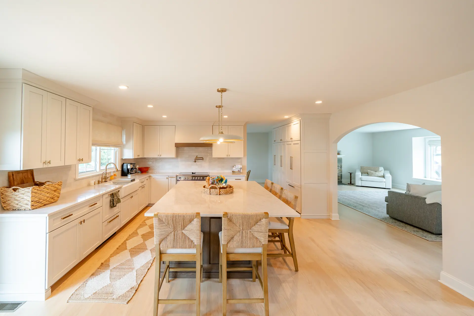Renovated kitchen with white Shaker cabinetry, Taj Mahal quartz countertops, and a large island
