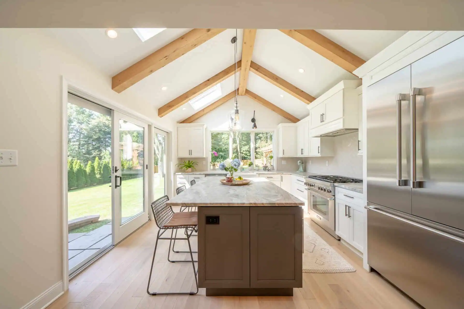 Kitchen with stainless-steel built-in refrigerator and island with contrasting grey color paint
