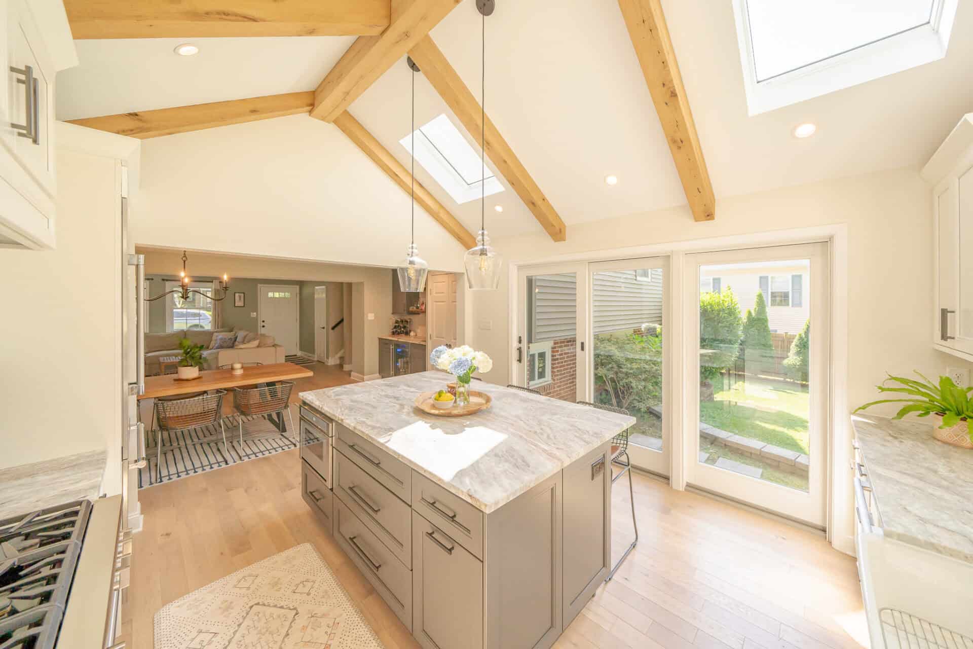 Sun-filled kitchen with skylights and island with three stools
