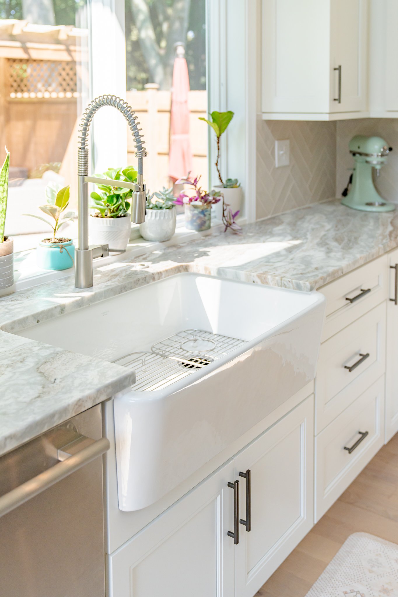 Kohler farmhouse sink in kitchen with marble countertops with a leather finish