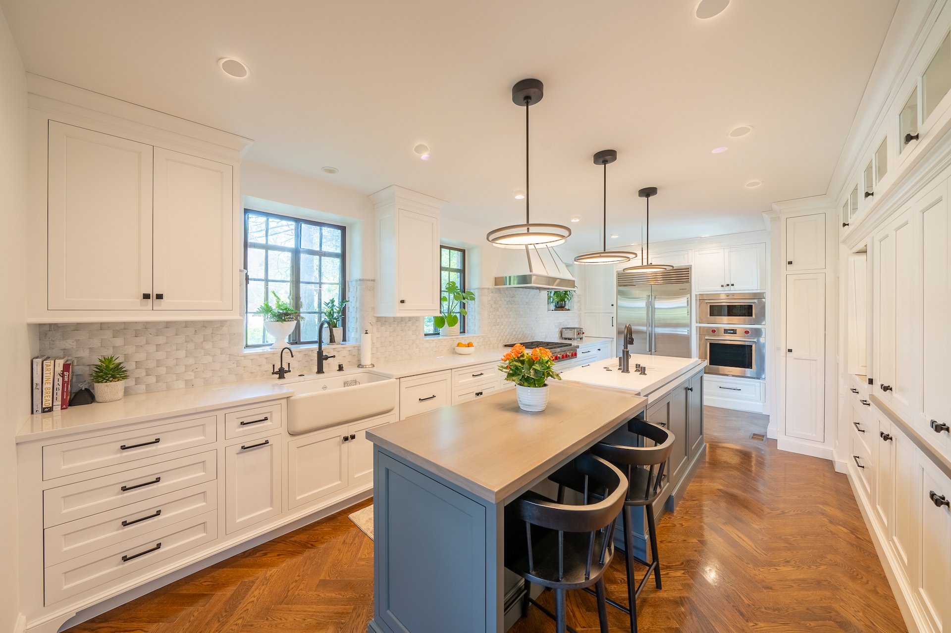 Remodeled kitchen with blue island and white cabinetry