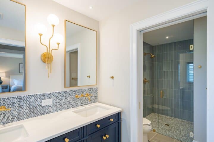 Bathroom with blue cabinets and gold cabinet hardware