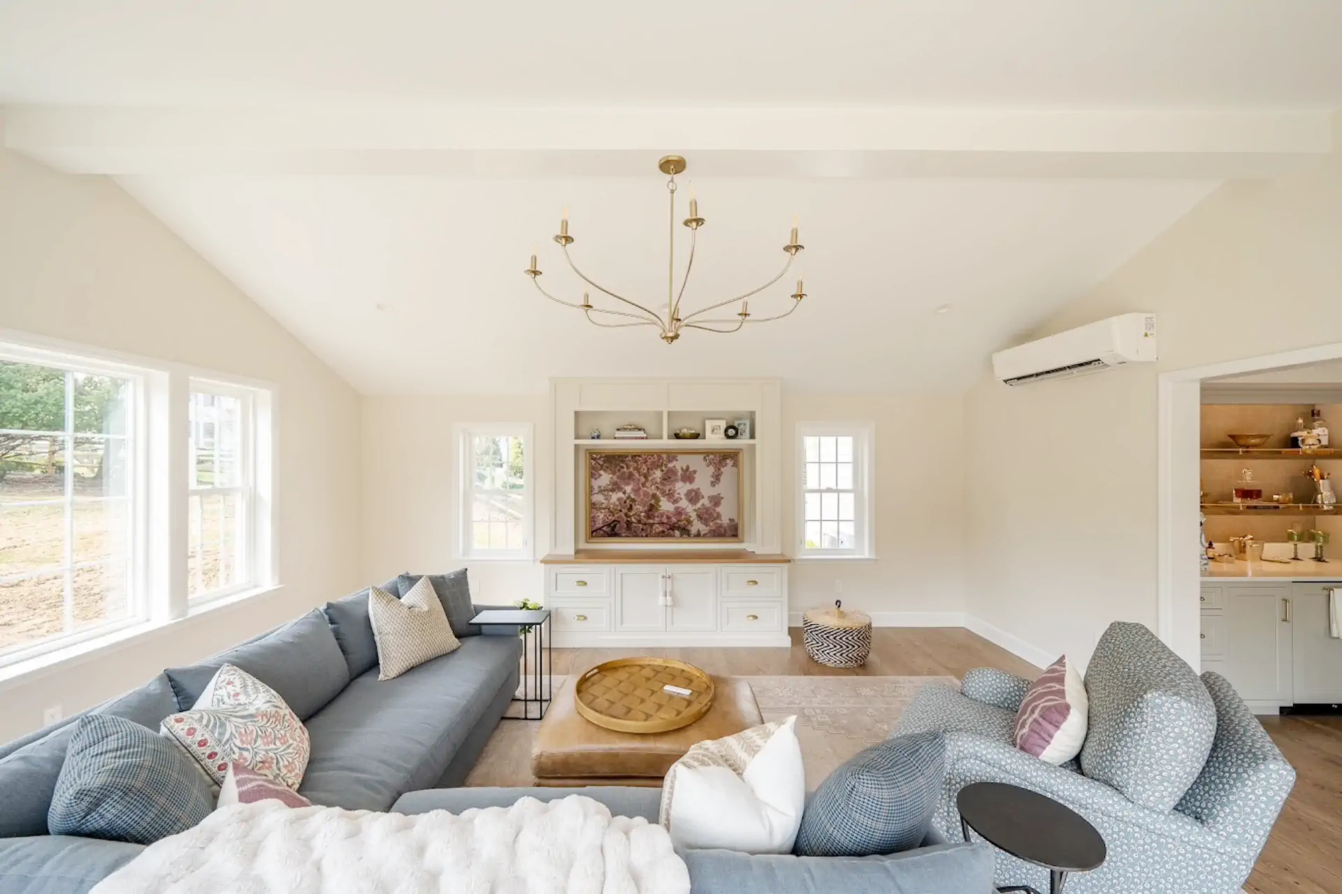 How Long Does It Take to Renovate a House: Timeline and What to Expect 1 Living room with L-shaped sofa, wooden coffee table, chandelier hanging from the ceiling and flowery painting on the wall