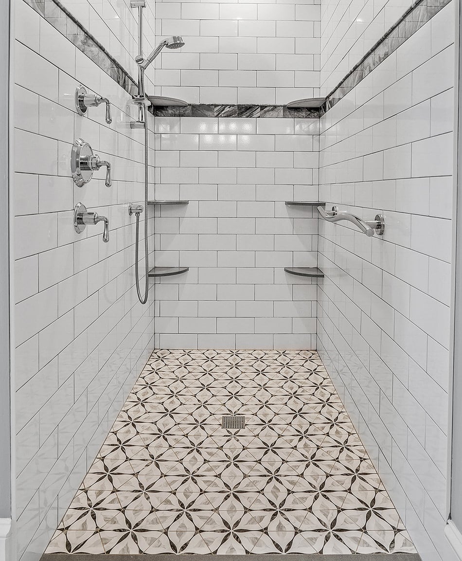 White tile shower with geometric patterned floor tile